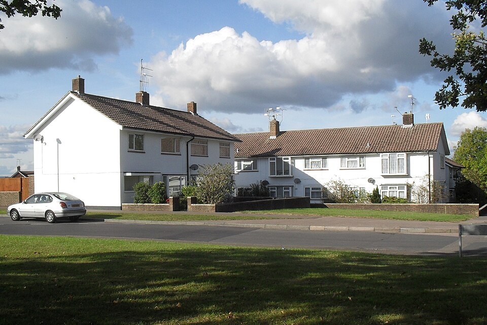 White semi-detached houses with front gardens on a sunny residential street