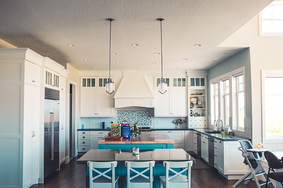 Kitchen-diner with a long table and chairs, white cupboards and pendant lights